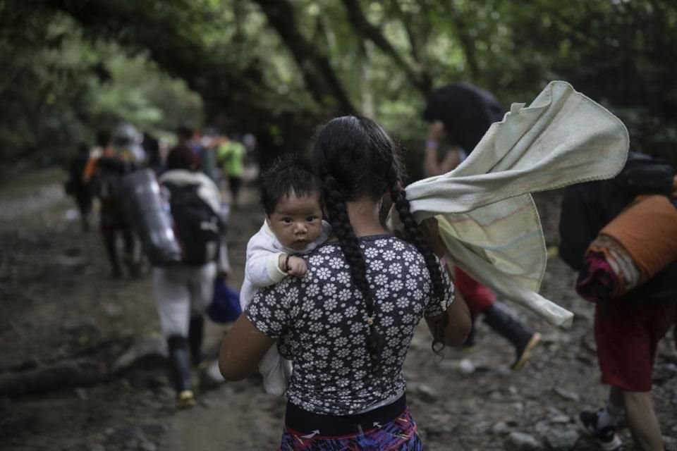 Una migrante boliviana carga un bebé mientras cruza el Tapón del Darién, de Colombia a Panamá, el 9 de mayo del 2023.