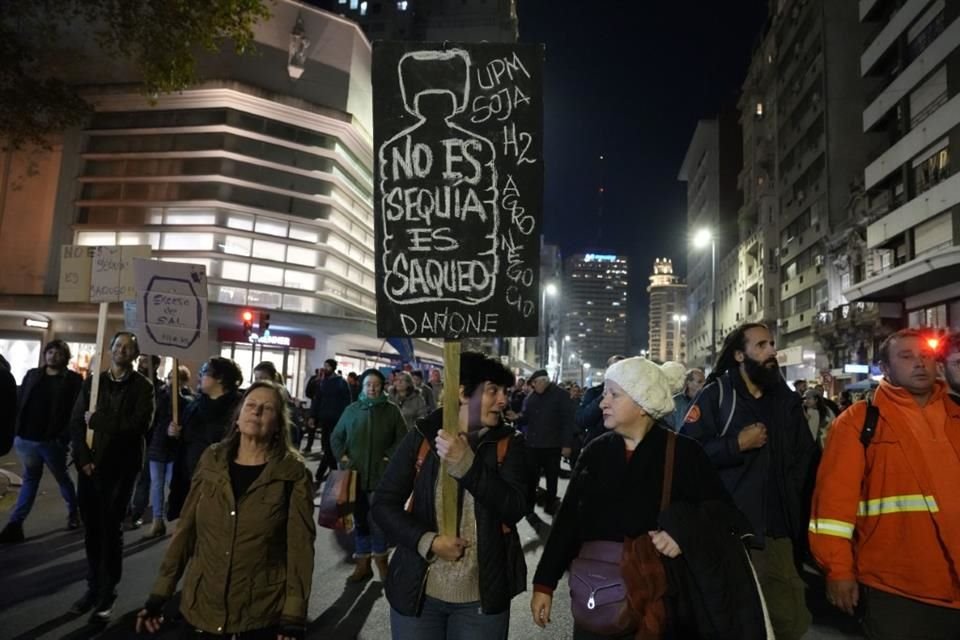 Una mujer sostiene una pancarta durante una marcha en defensa del agua convocada por organizaciones sociales, en Montevideo, capital de Uruguay, el 31 de mayo de 2023.