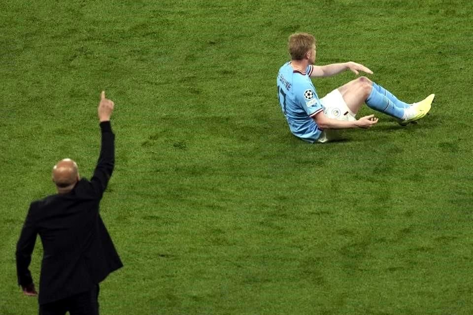 Kevin De Bruyne yace en el suelo mientras Pep Guardiola, su DT, da indicaciones.