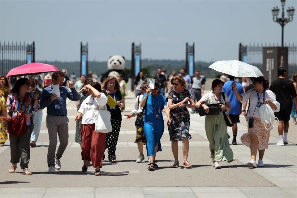 Los turistas se protegen del sol en una visita al Palacio Real de Madrid el 26 de junio.