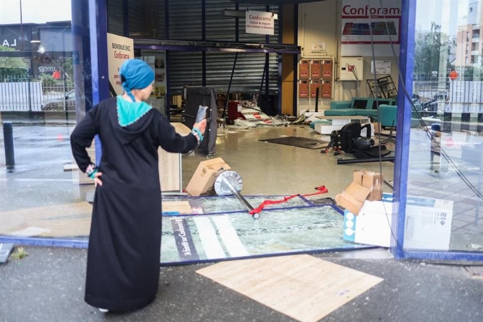 Una mujer observa los daños a una tienda causados durante las protestas por el asesinato de un joven, en Bondy, Francia, el 1 de julio.