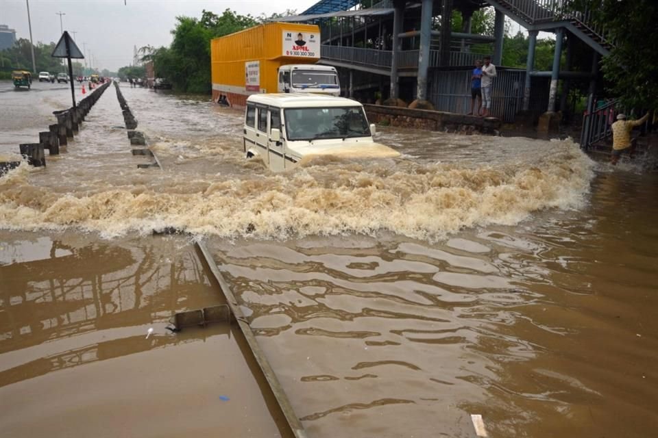 Un viajero conduce su automóvil a lo largo de una autopista inundada después de fuertes lluvias monzónicas en Gurgaon, en las afueras de Nueva Delhi.