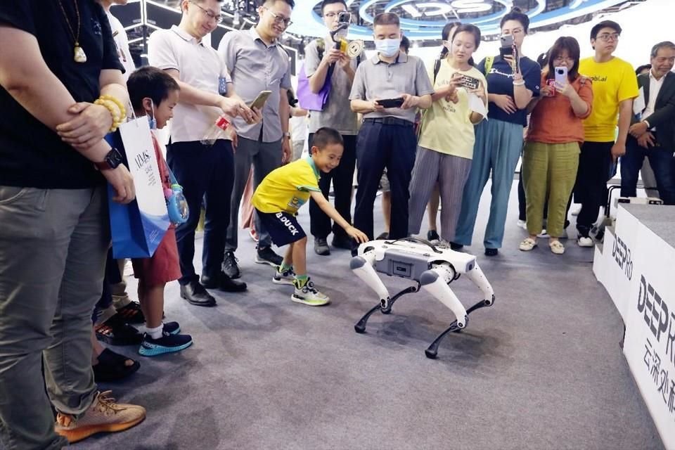 Audiencia interactúa con un perro robot.