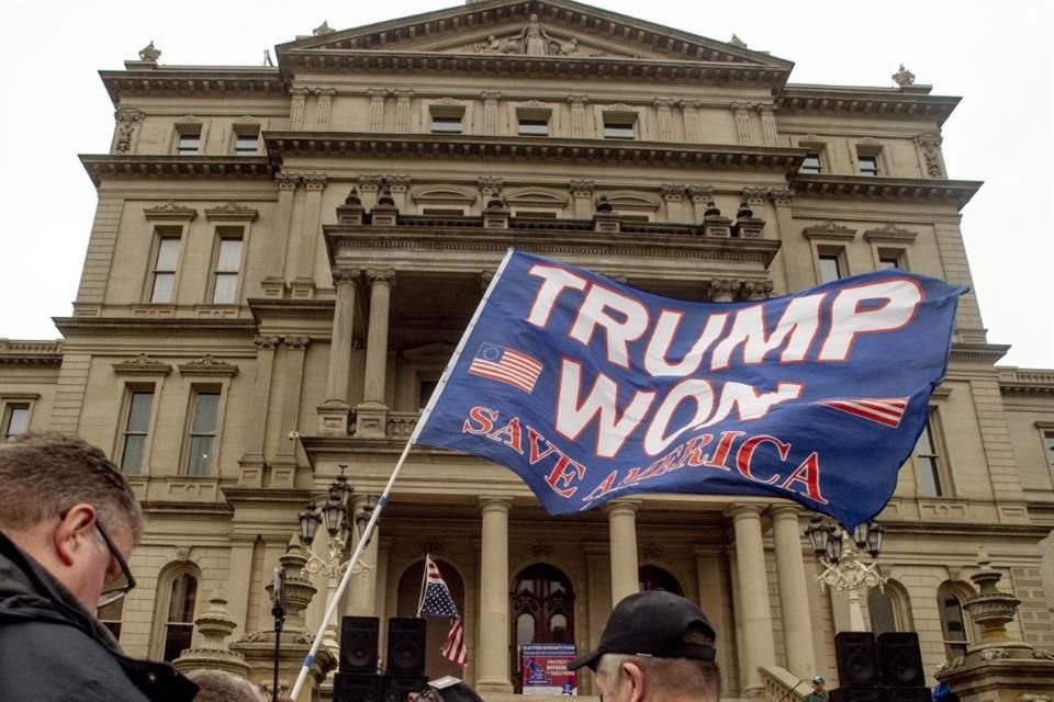 Un manifestante ondea una bandera en favor de Trump durante una protesta frente al Capitolio estatal de Michigan, el 21 de octubre de 2022.