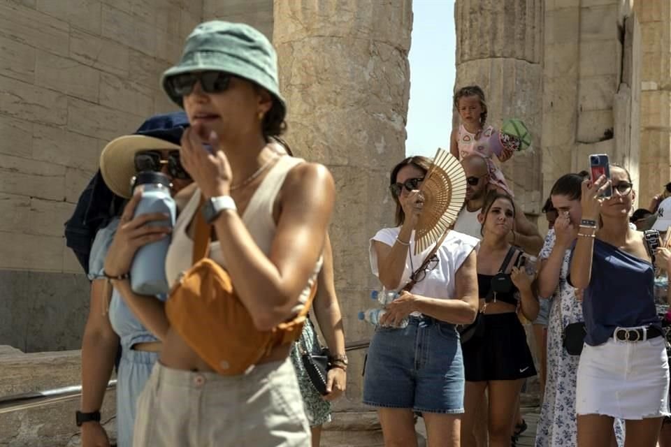 Los turistas visitan la antigua colina de la Acrópolis durante una ola de calor en Atenas, Grecia.