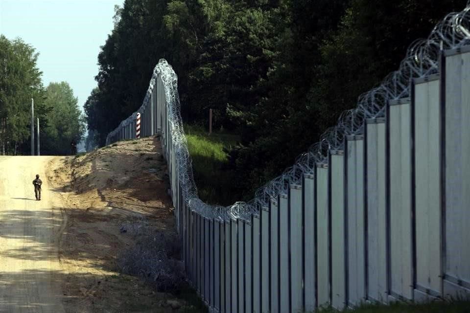 Un guardia fronterizo polaco patrulla el muro de metal construido en la frontera entre Polonia y Bielorrusia.