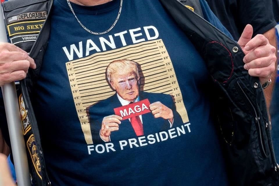 Un manifestante muestra su playera ante la corte donde Trump comparecerá por su papel en la insurrección del 6 de enero.