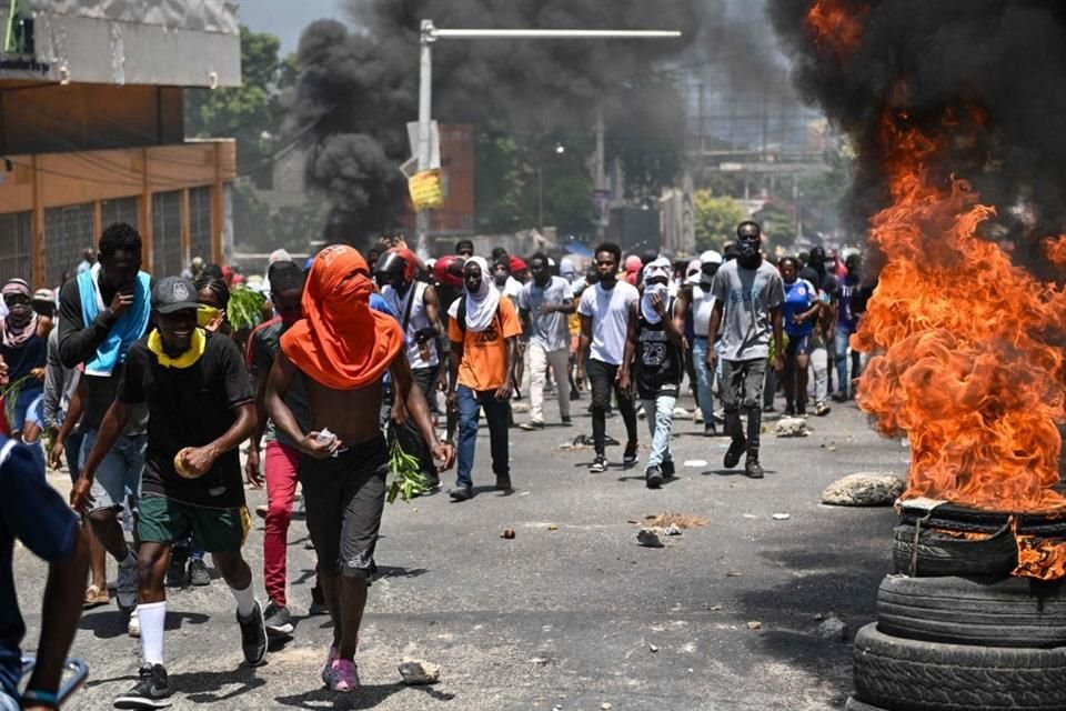 Personas marchan junto a llantas quemadas durante una protesta contra la inseguridad en Puerto Príncipe.