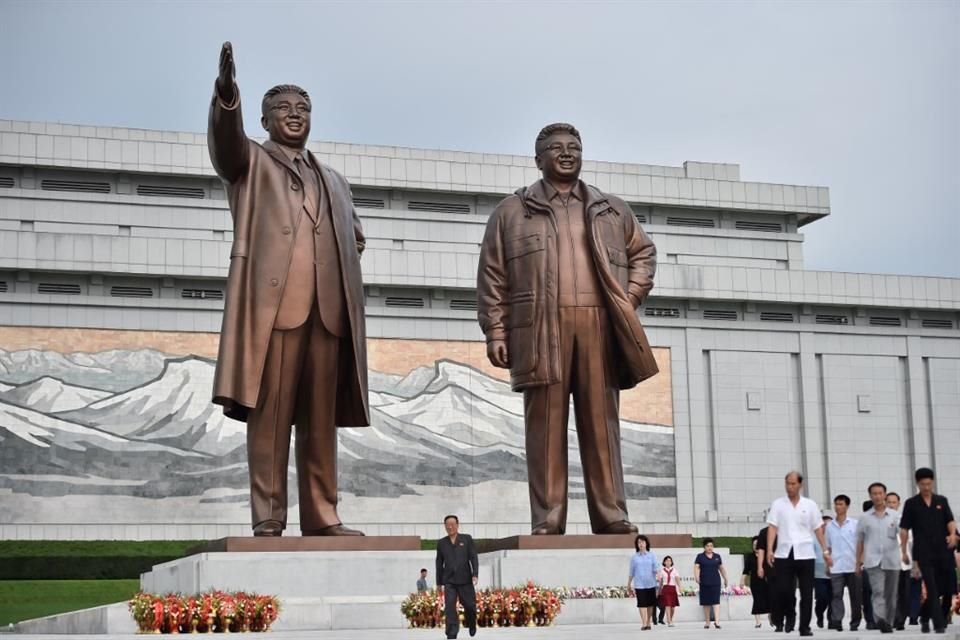 Personas caminan frente a las estatuas de los líderes norcoreanos Kim Il Sung y Kim Jong Il, el 15 de agosto.