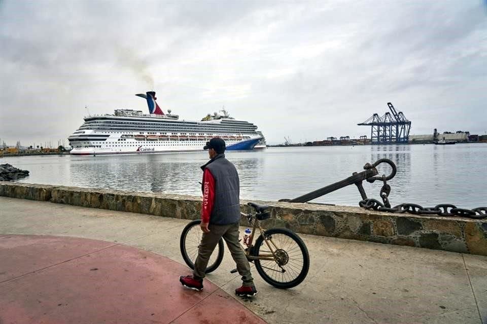 Un hombre pasa con su bicicleta en el muelle antes de la llegada del huracán Hilary, en Ensenada, México.