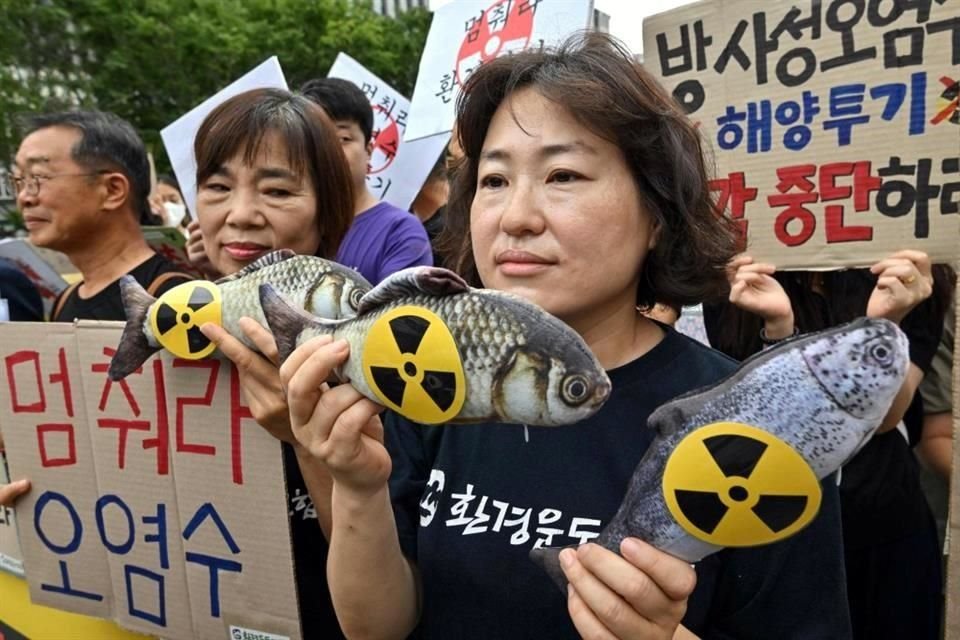 Activistas medioambientales surcoreanos sostienen muñecos de peces con signos radiactivos en una manifestación contra el plan japonés de liberar aguas residuales de la dañada planta nuclear Fukushima.