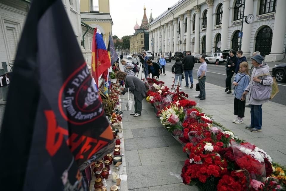 La gente se encuentra junto a un monumento callejero con velas encendidas para los miembros del grupo militar del Grupo Wagner que murieron en un accidente aéreo.