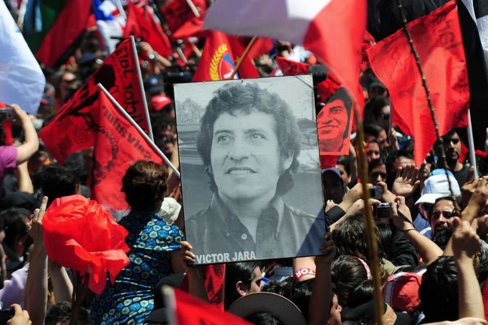 Personas sostienen un retrato del cantautor chileno Víctor Jara durante su funeral en 2009 luego de que sus restos, que estuvieron ocultos 36 años, fueron exhumados.