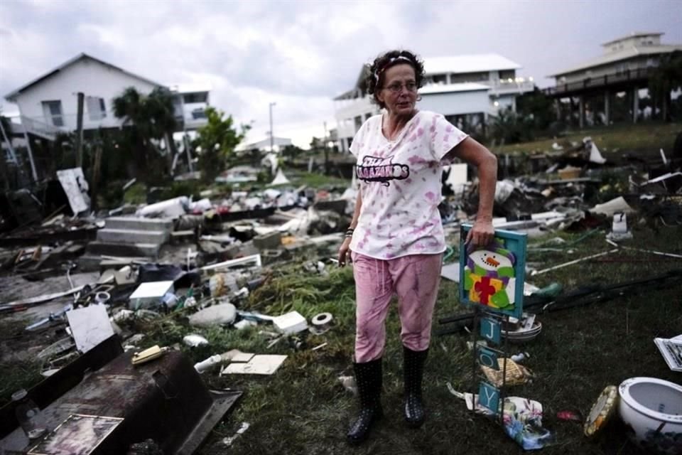 Jewell Baggett se encuentra junto a una decoración navideña que recuperó de los escombros de la casa de su madre, en Horseshoe Beach, Florida.