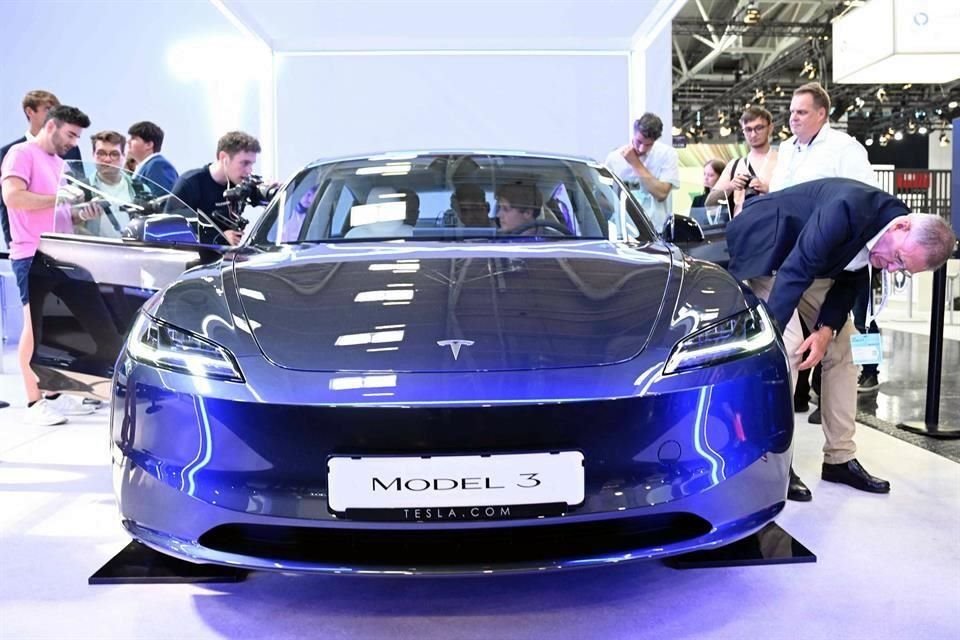 Visitantes inspeccionan un automóvil Tesla Model 3 expuesto en el Salón Internacional del Automóvil (IAA).