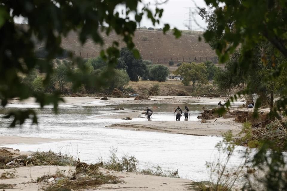 Oficiales de la Guardia Civil registran un río en la Aldea del Fresno, en Madrid.