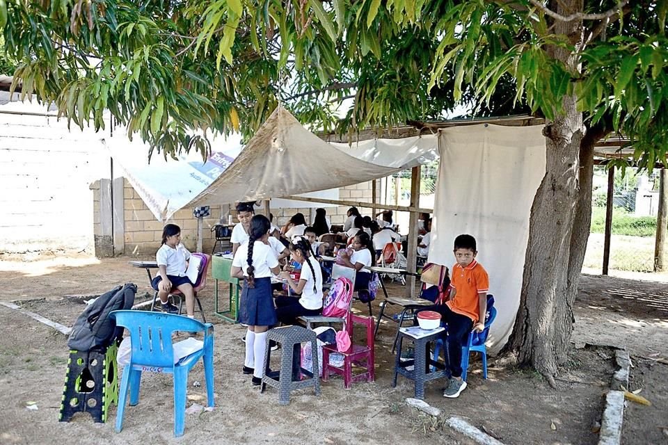 Las precarias condiciones de una primaria en Acapulco obligan a alumnos a tomar clase bajo láminas y lonas, y llevar sillas de su casa.