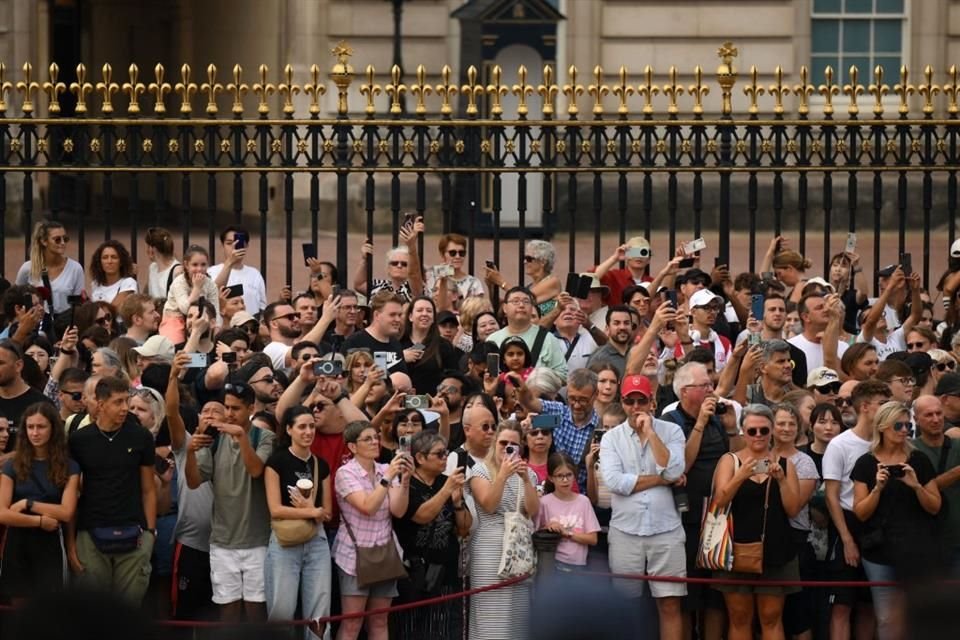 Aún más personas de todas las edades se juntaron en el enrejado a las afueras del palacio de Buckingham en espera del inicio del evento conmemorativo.