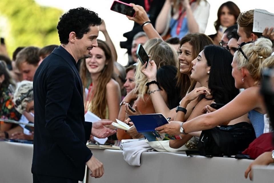 El director estadounidense y presidente del jurado, Damien Chazelle, firma autógrafos durante la alfombra roja.