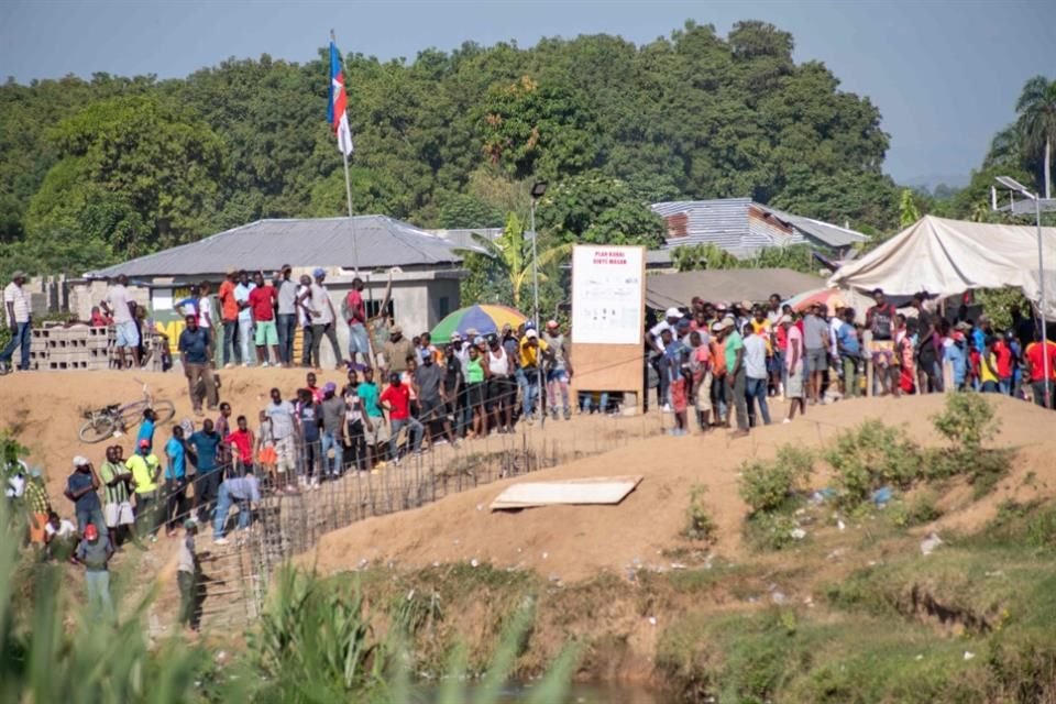 Haitianos esperan a orillas del río Masacre, en la frontera entre Haití y República Dominicana.