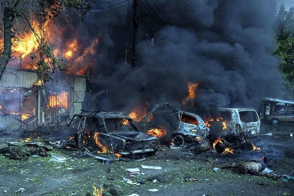 Un cadáver yace en el suelo frente a un mercado en llamas después de un ataque de bombardeo, que pruebas muestran fue un misil ucraniano.