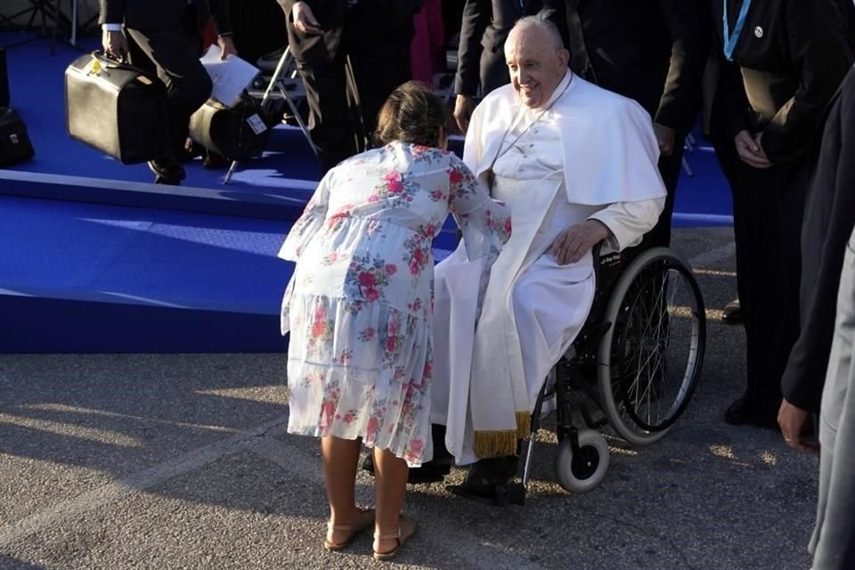 El Papa Francisco es recibido por una niña mientras participa en un momento de reflexión con líderes religiosos junto al Memorial dedicado a los marineros y migrantes perdidos en el mar.