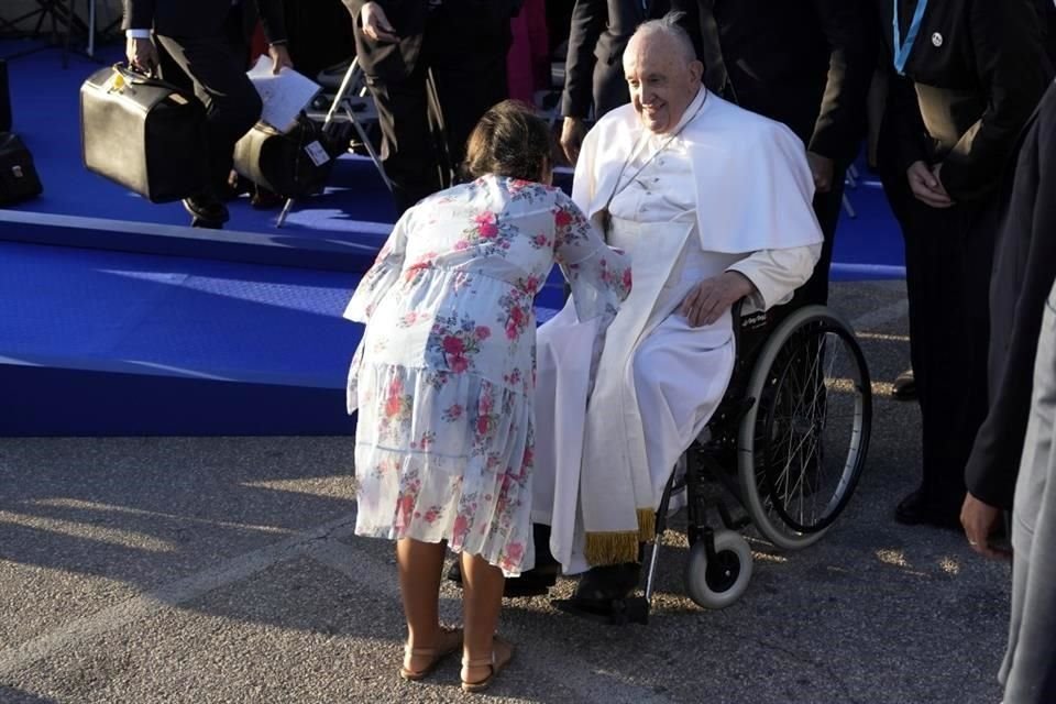 El Papa Francisco es recibido por una niña mientras participa en un momento de reflexión con líderes religiosos junto al Memorial dedicado a los marineros y migrantes perdidos en el mar.