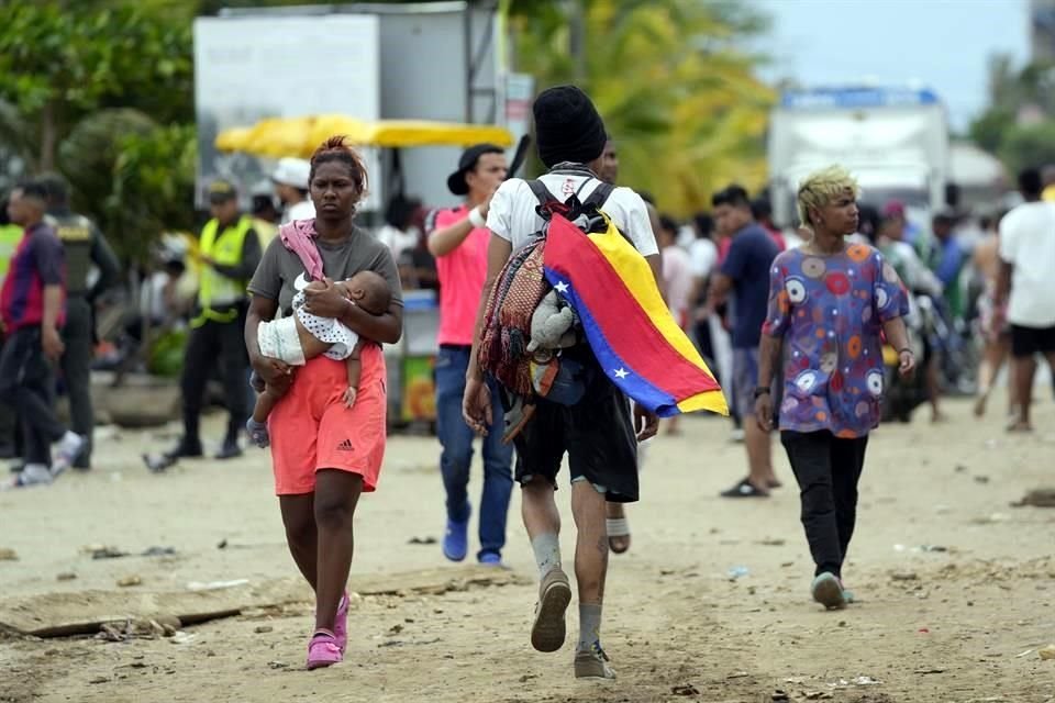 Un migrante porta una bandera venezolana en su camino a Estados Unidos.