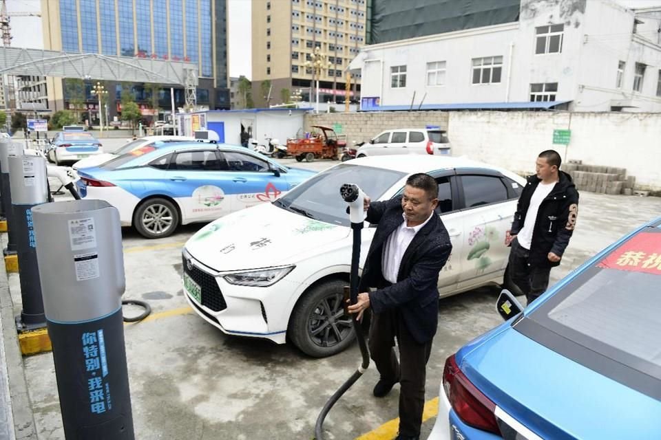 Un taxista carga su automóvil eléctrico en una estación de carga en el condado Anlong. La empresa de taxis para la que trabaja el conductor ya puso en servicio 70 coches eléctricos en 2020.