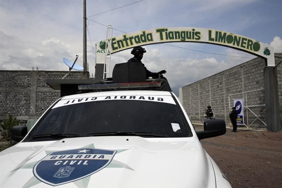 Miembros de la Guardia Nacional hacen guardia en la entrada del mercado limonero en Apatzingán, Michoacán.