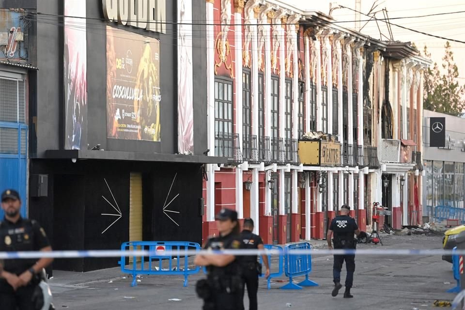 Policías resguardan la escena de un incendio en una discoteca en España donde murieron 13 personas.