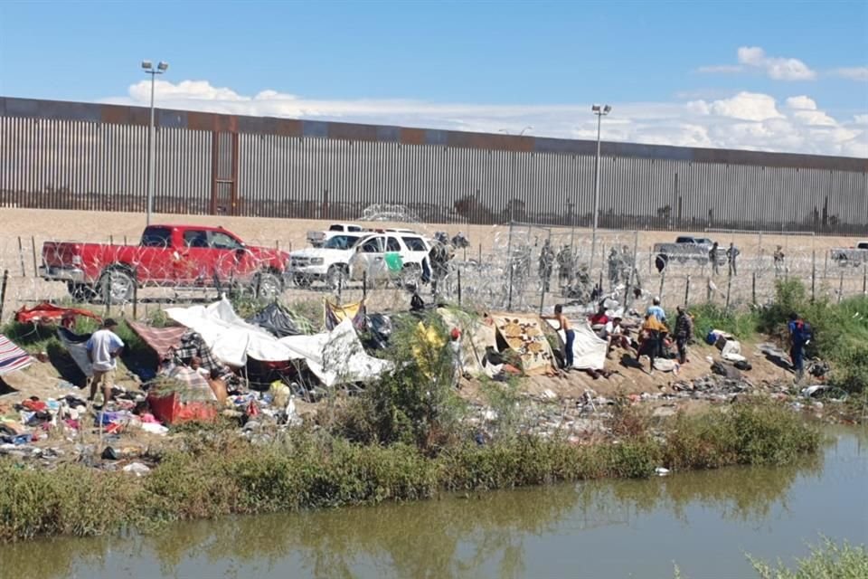 Una alambrada de púas divide dos campamentos de migrantes; en uno personas esperan que les abran el acceso para formarse en la segunda 'aldea' y tramitar su solicitud de refugio.