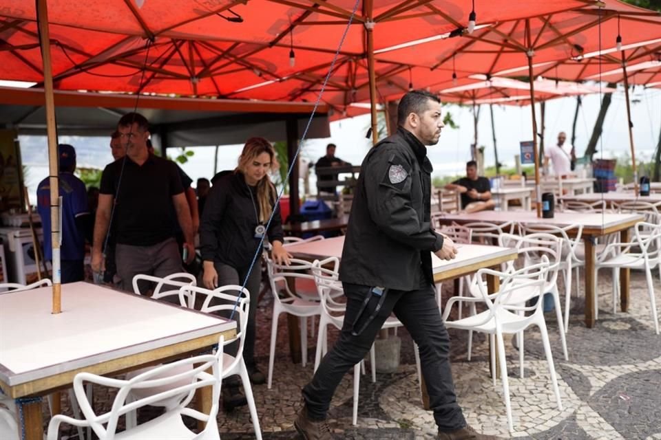 Policías investigan un bar donde tres doctores fueron asesinados en Rio de Janeiro.