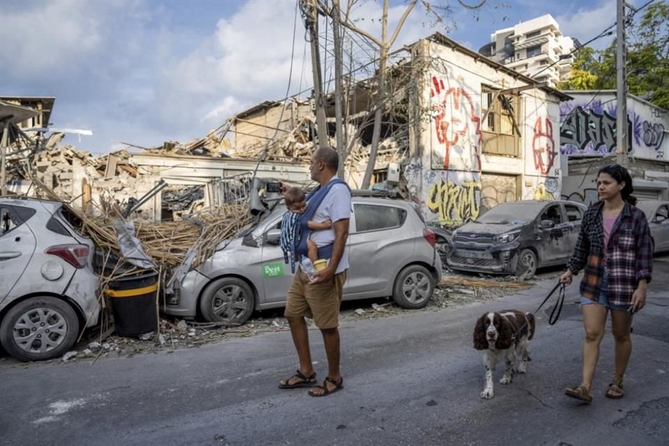 Los israelíes inspeccionan los escombros de un edificio un día después de que fuera alcanzado por un cohete disparado desde la Franja de Gaza, en Tel Aviv, Israel.