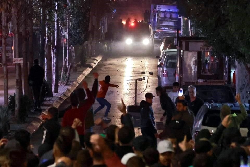 La gente choca con las fuerzas de seguridad palestinas durante una manifestación de solidaridad con los palestinos de la Franja de Gaza en la ciudad de Ramalá, en Cisjordania.