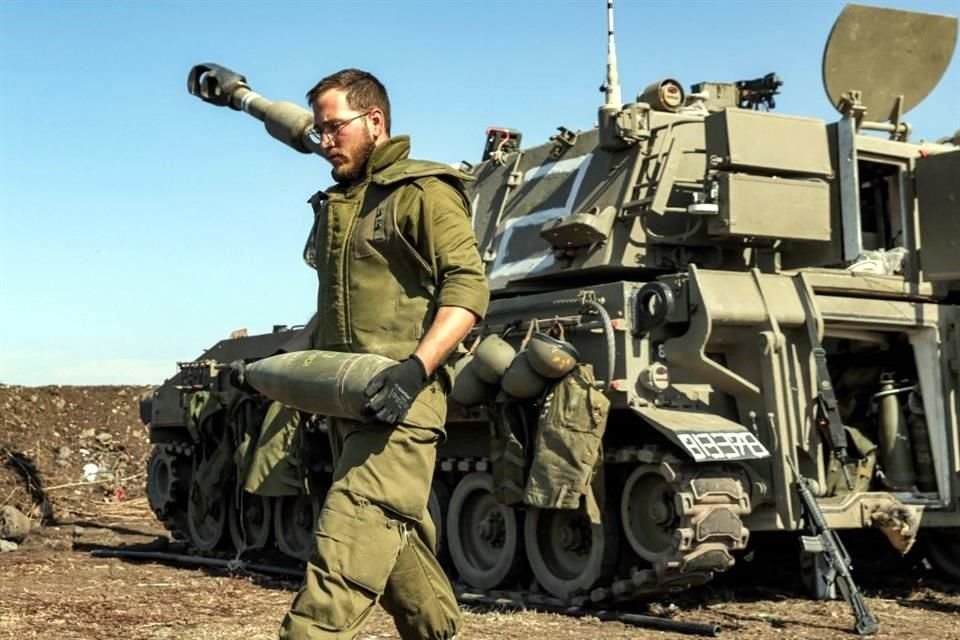 Un soldado del Ejército israelí transporta un proyectil de artillería de 155 mm.