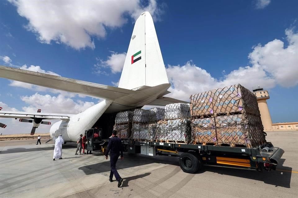 Personal descarga ayuda para la Franja de Gaza desde un avión de carga de Emirates en la pista del aeropuerto egipcio de El-Arish.