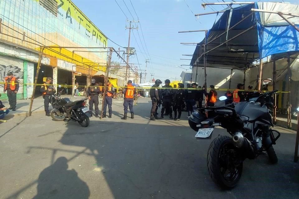 Policías se desplegaron en el lugar para resguardar los cuerpos que fueron cubiertos con sábanas y lonas de puestos ambulantes aledaños.