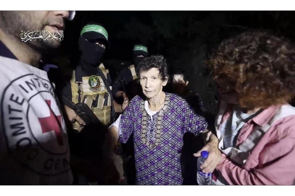 En esta imagen, tomada de un video distribuido por las Brigadas Al Qassam en su canal de Telegram, muestra a Yocheved Lifshitz, de 85 años, estrechando la mano de miembros de Hamas tras su liberación.