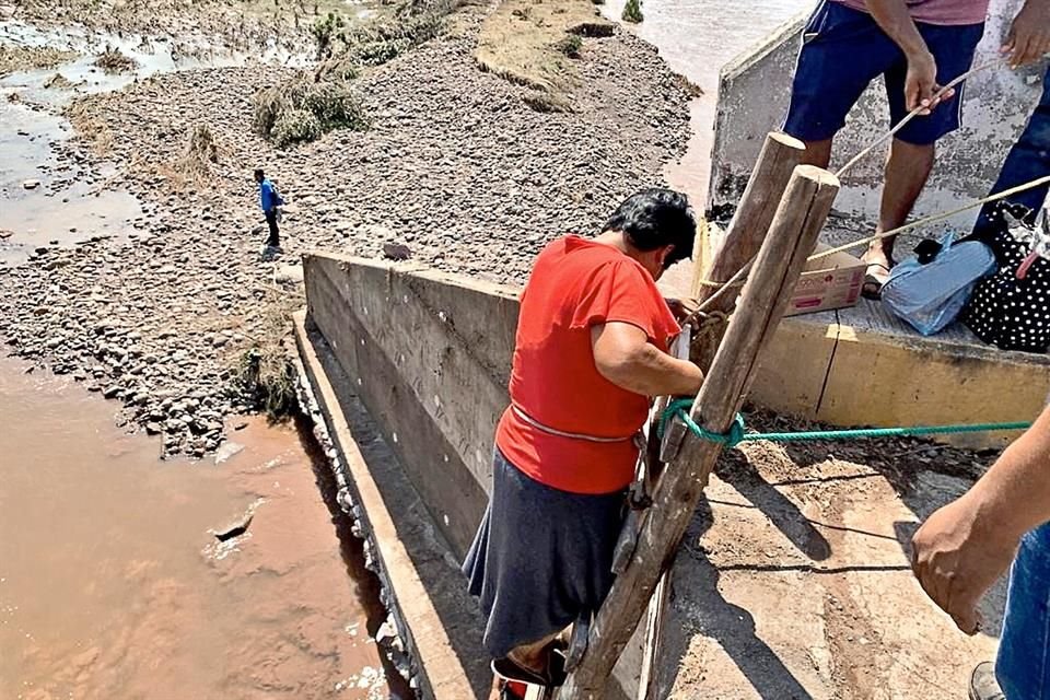 Debido al desplome del puente que permitetransitar de Ajuchitlán a San Miguel Totolapan, se improvisó una escalera que por ahora constituye la única forma de pasar.