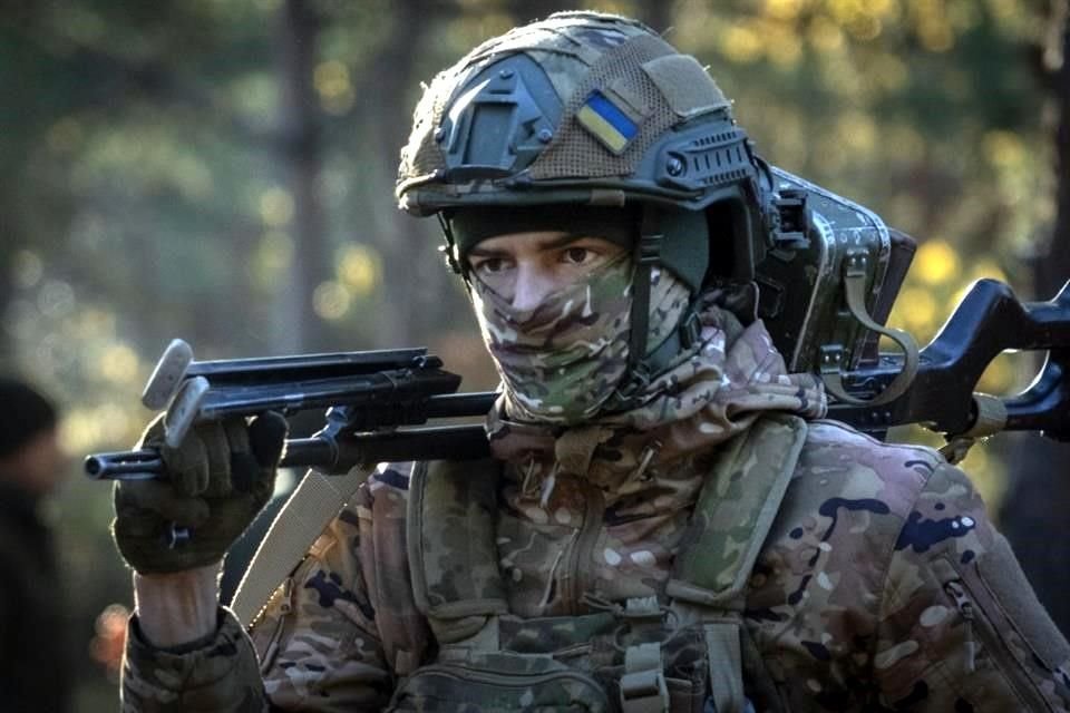 Un soldado de la primera brigada Bureviy de la Guardia Nacional de Ucrania camina durante el entrenamiento de combate en un campo de entrenamiento militar en el norte de Ucrania.