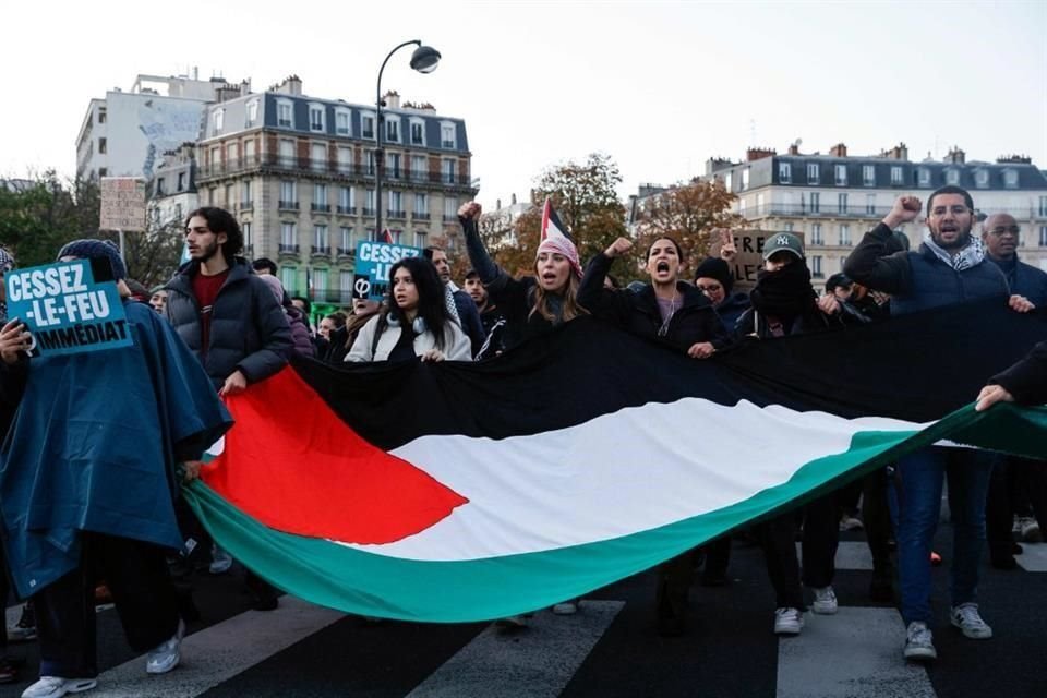 Los manifestantes enarbolan una bandera palestina durante una manifestación 'en solidaridad con el pueblo palestino' en París.