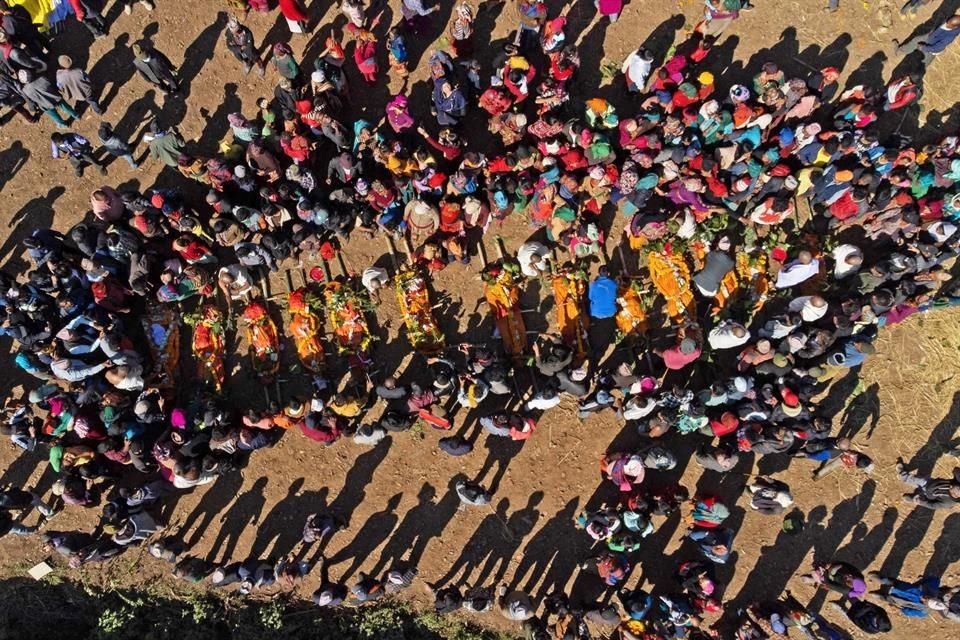 Familiares de víctimas de un terremoto en Nepal se congregan alrededor de cuerpos durante una ceremonia de cremación.