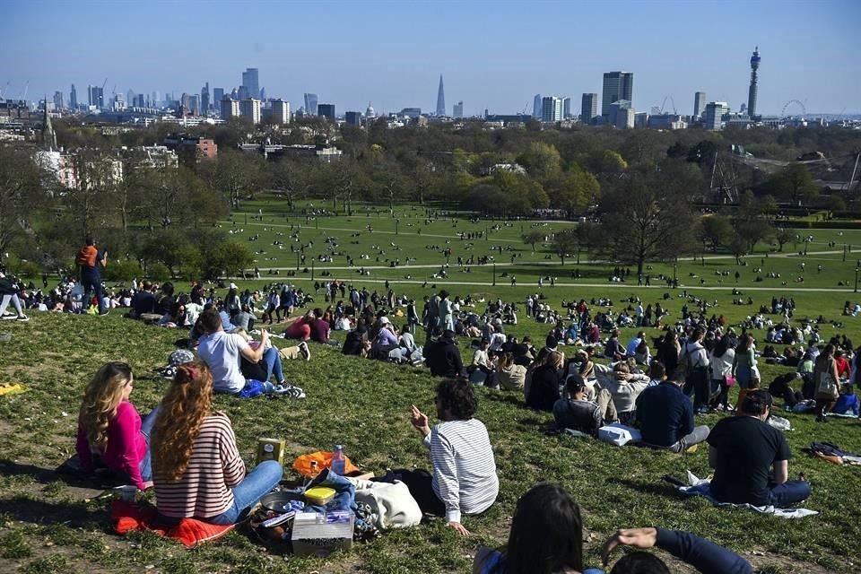 Personas descansan en Primrose Hill, Londres, este domingo.