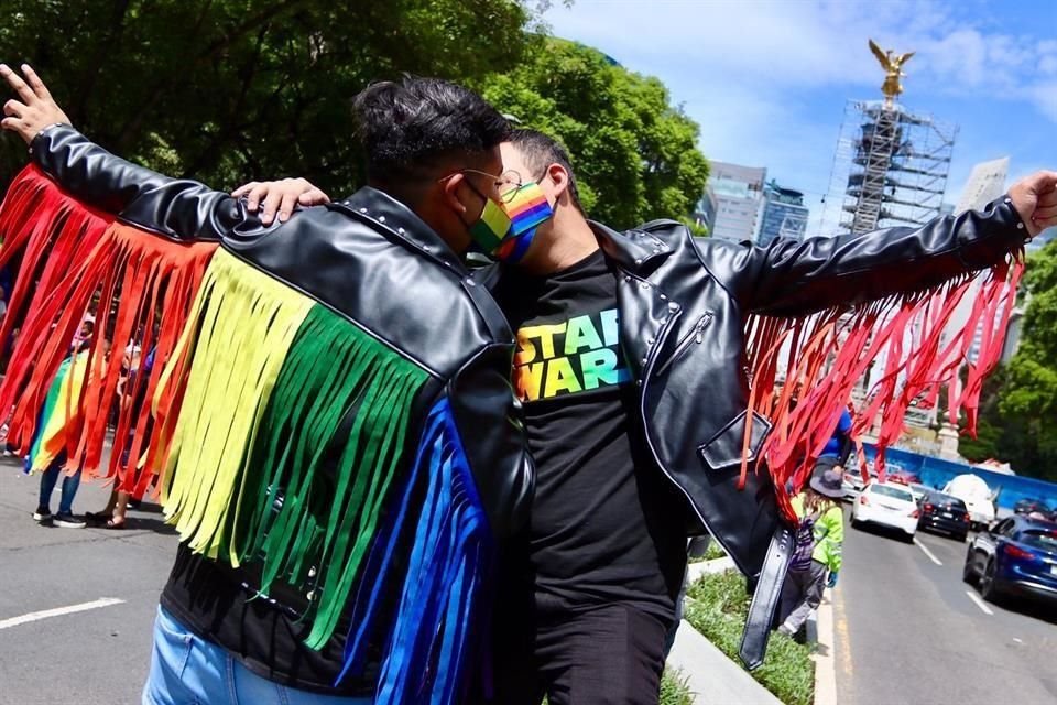 Dos jóvenes comparten su afecto en el Paseo de la Reforma.