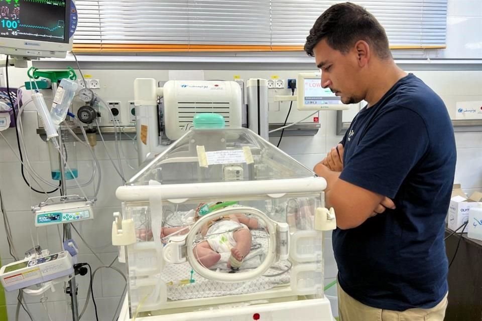 Un padre observa a su hija mientras recibe atención médica en un hospital de Rafah.