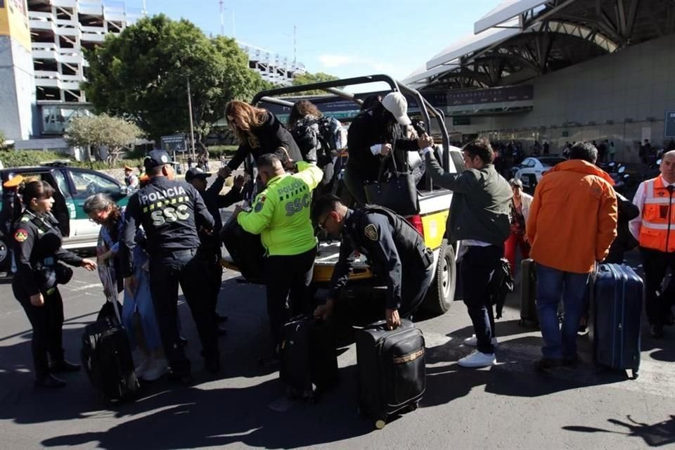 Policías ayudan a trasladar a usuarios a la Terminal aérea.