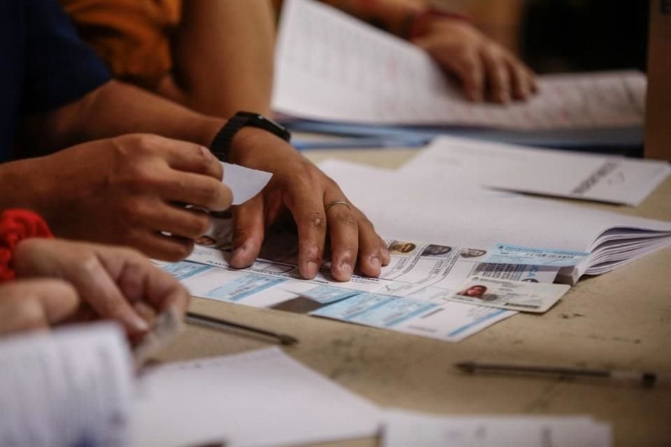 Personal electoral checa un ID en una casilla en Buenos Aires.