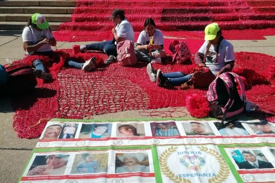 El Colectivo Hilos realiza una instalación con hilo rojo tejido para simbolizar la sangre de mujeres que han sido víctimas de violencia.