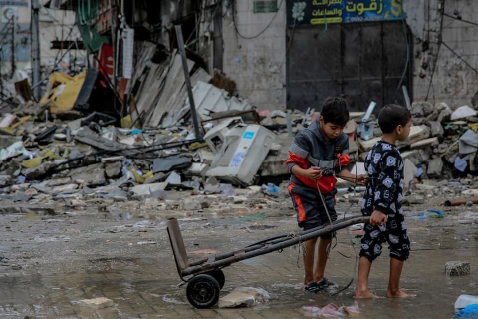 Dos niños palestinos arrastran un diablito por las calles de la ciudad de Gaza, el 27 de noviembre del 2023.